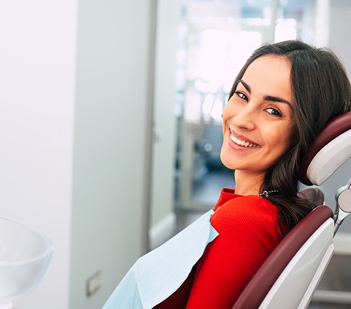 Female patient in red shirt smiling in dental chair