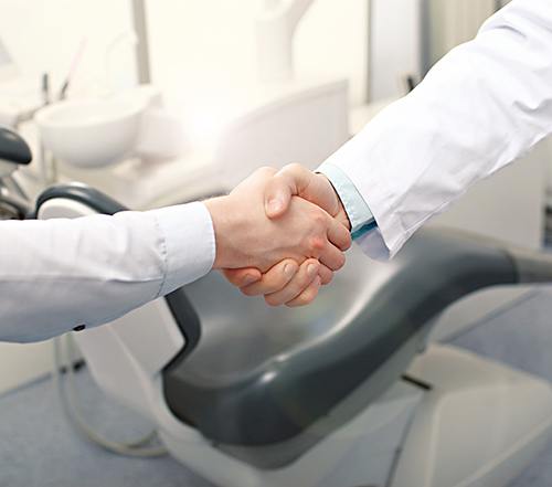 Close-up of patient and dentist shaking hands