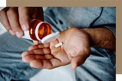 Person taking a white pill out of a bottle