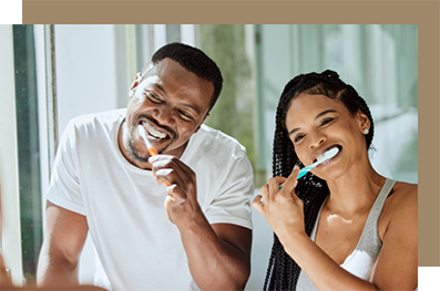 Man and woman brushing their teeth together