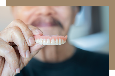Man holding his denture in front of him