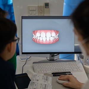 Dentist reviewing scan of teeth with patient