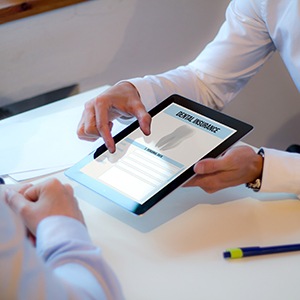 Dentist reviewing dental insurance form with patient