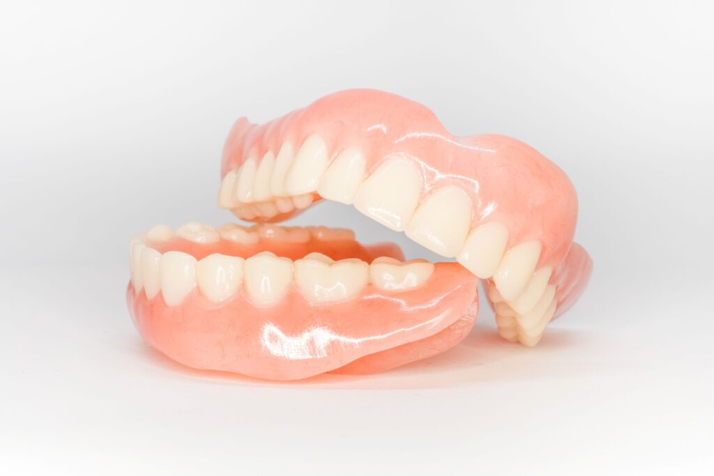 Upper dentures resting on lower ones with white background