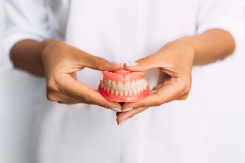 Lady presents viewer with dentures